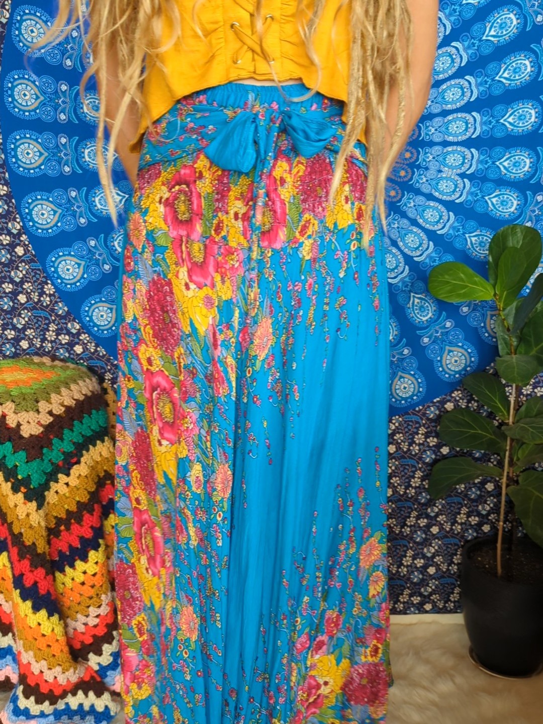 A woman with long hair wearing a yellow top and blue skirt, exuding elegance and style.