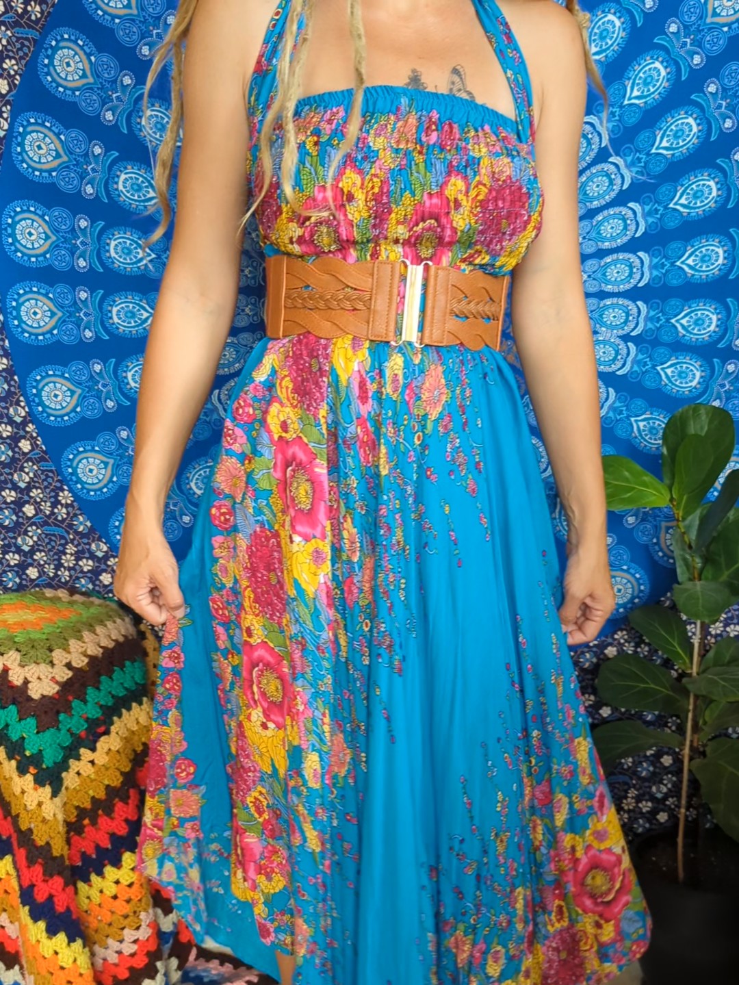A woman in a vibrant blie dress with a leather belt.