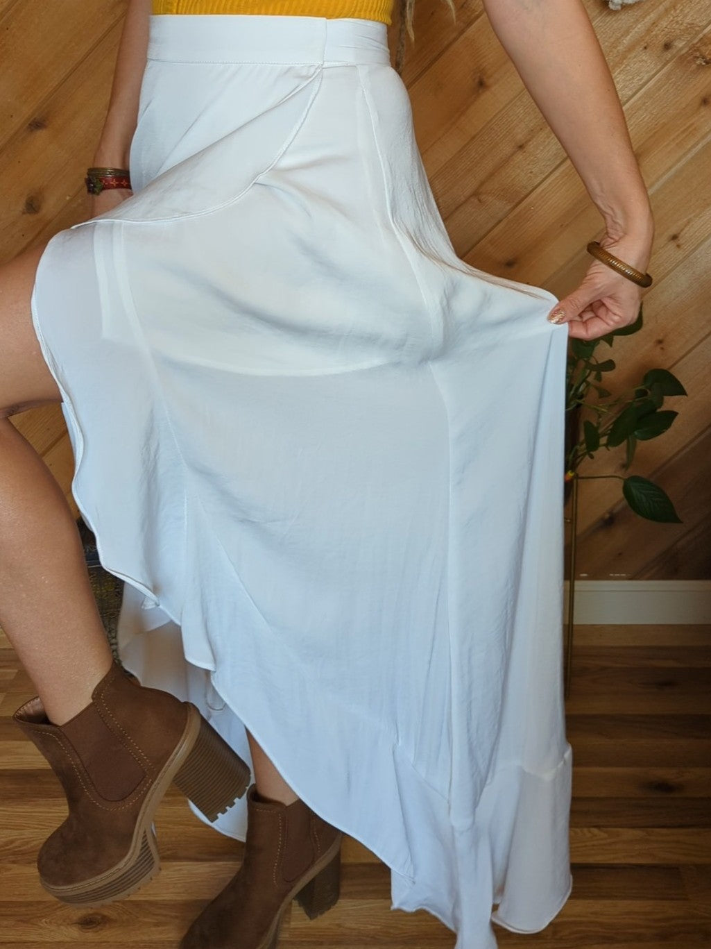 Side view of wla woman in yellow top and white skirt showcasing the cut of the skirt and ruffled edge.