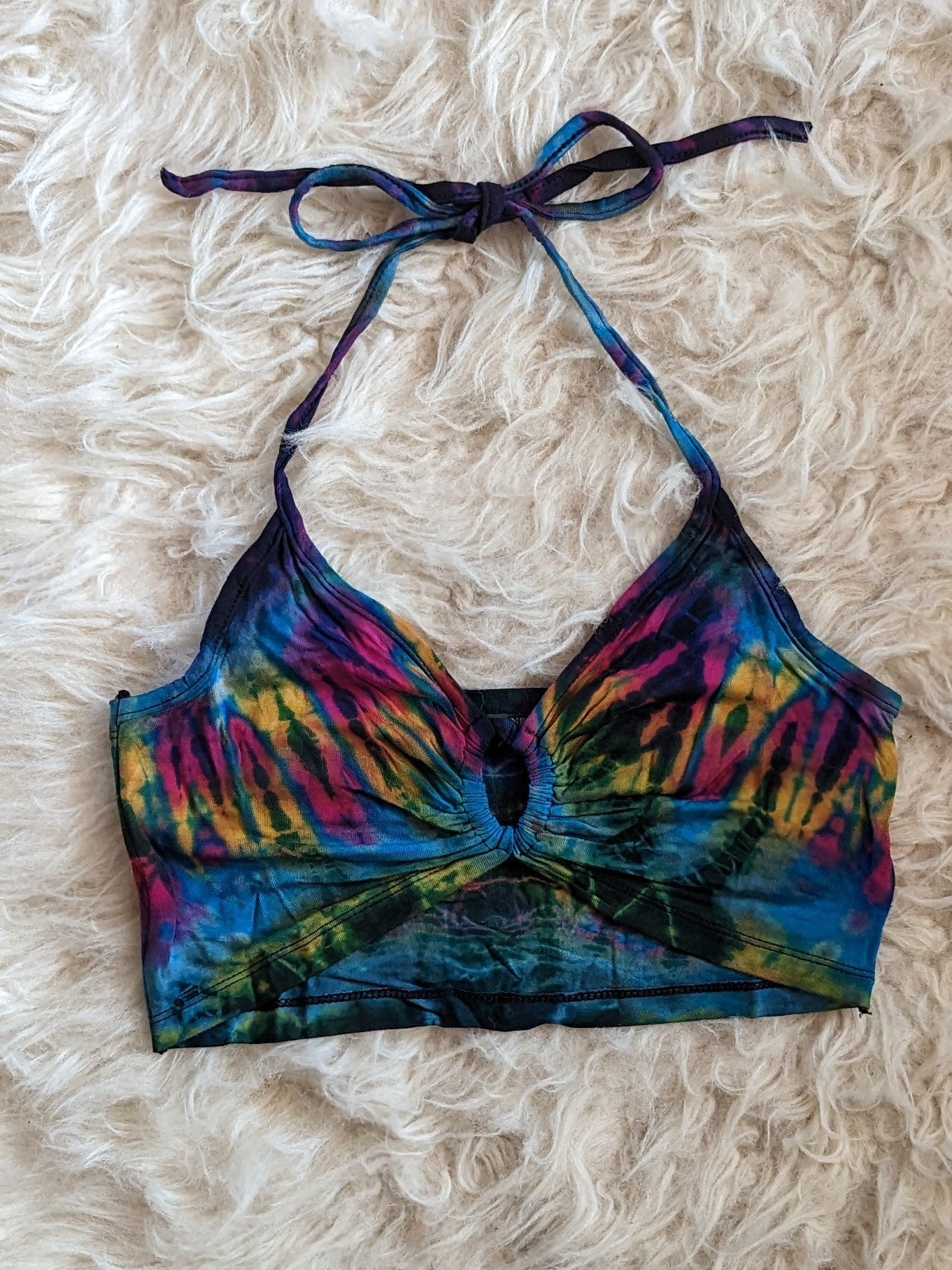 Light blue tie dye halter top lays on ehite fur.